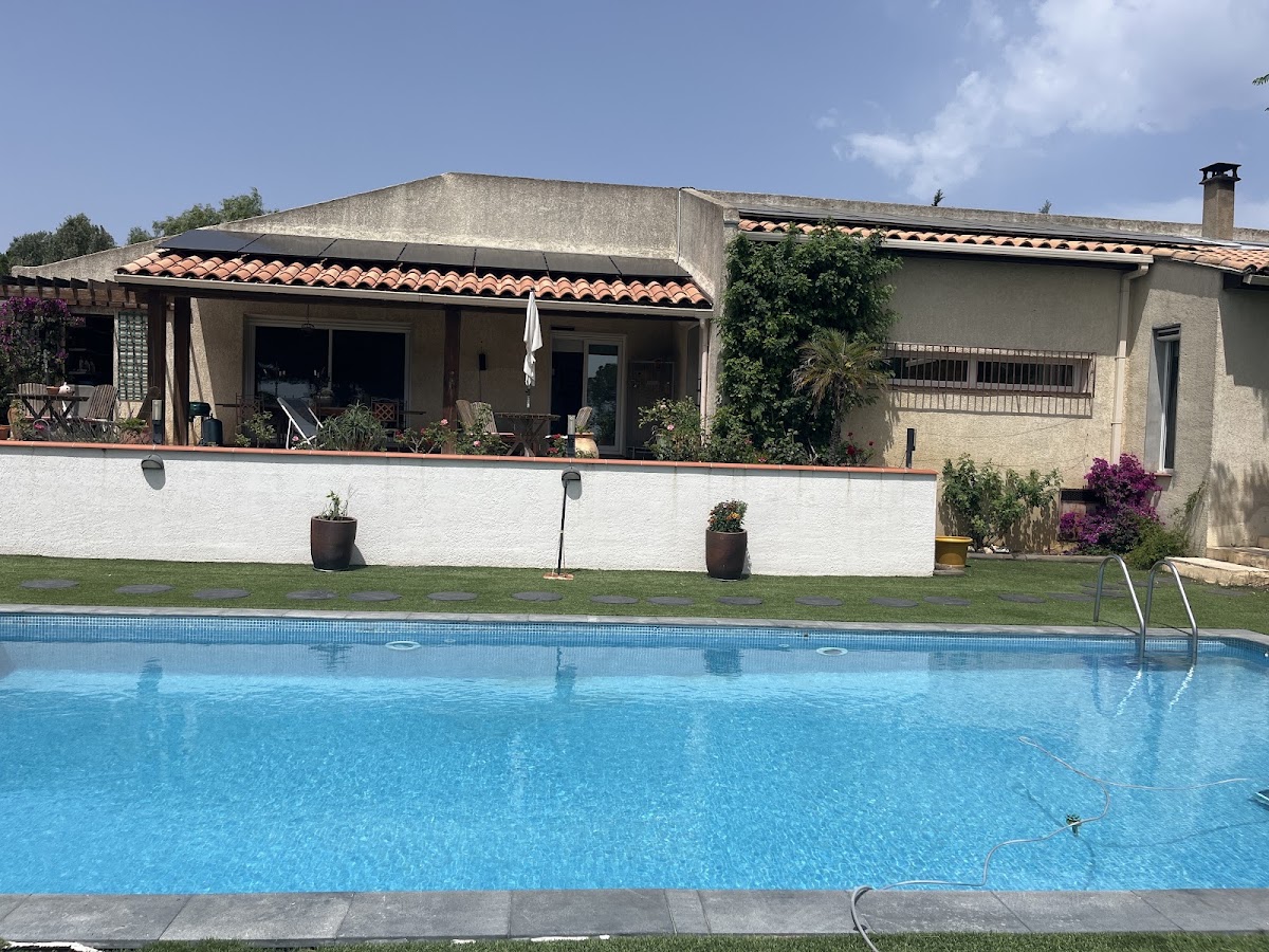 Installation solaire en toiture, vue depuis le jardin avec piscine
